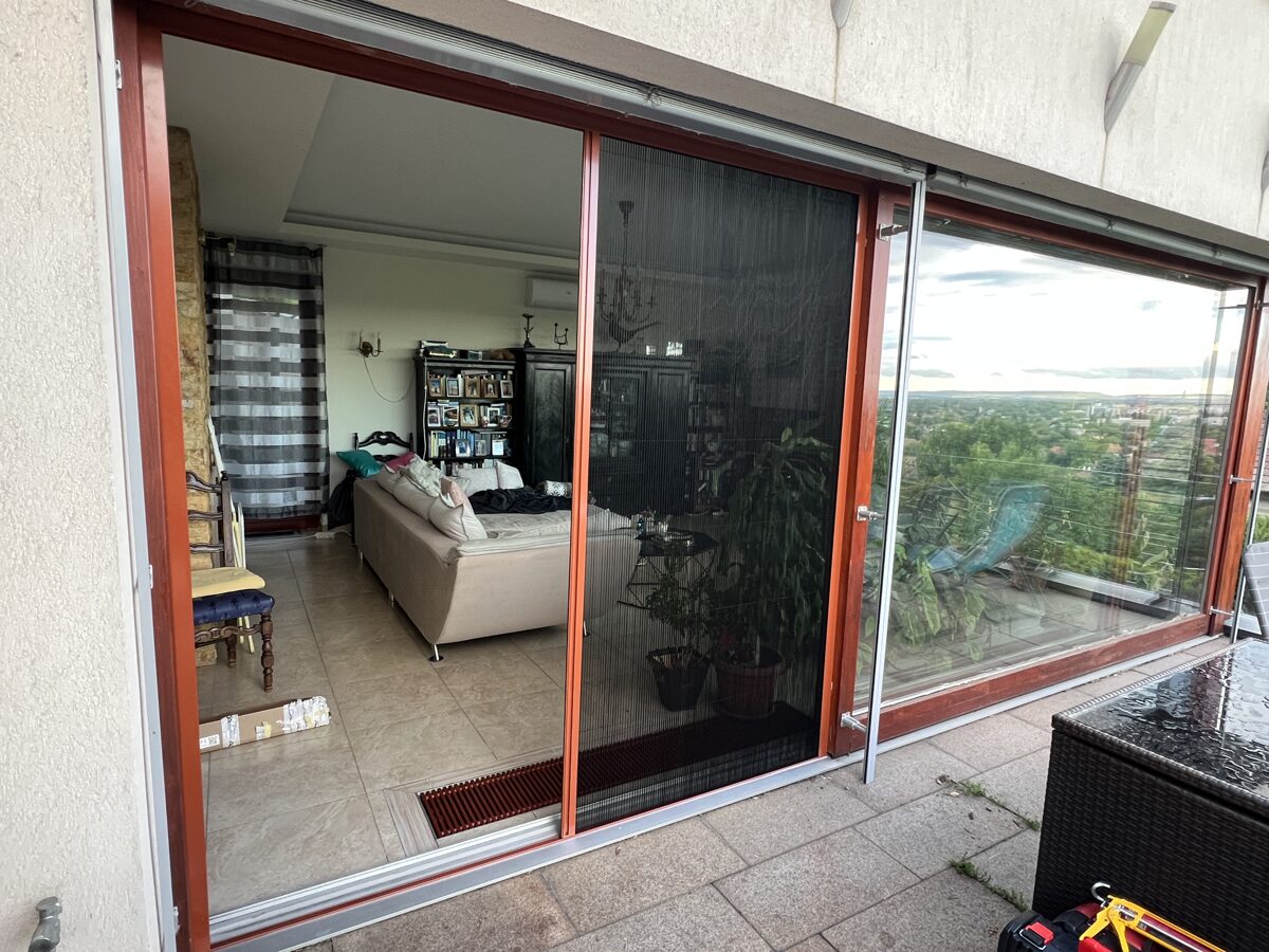 Pliszé szúnyogháló tolóajtón, ami megvédi a beltéri nappalit a rovaroktól.